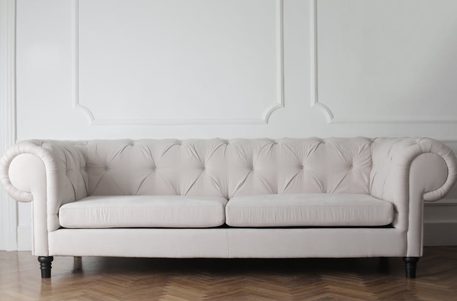 A long row of vibrant blue upholstered seating with rectangular backrests and seat cushions, arranged along a white wall in a well-lit indoor space. The surface of the upholstery appears clean and smo